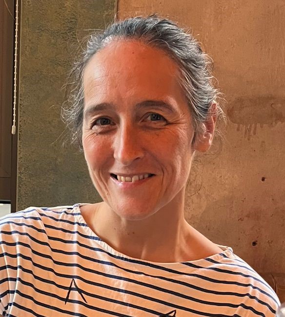 Emma Horrel smiling wearing a white and black striped top